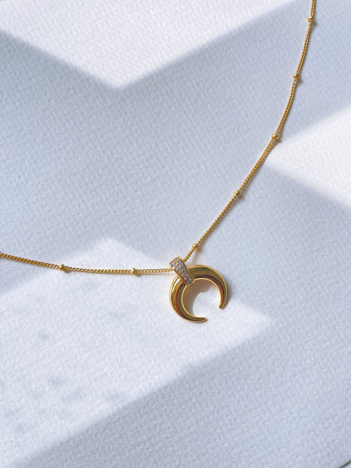 Crescent-shaped pendant necklace