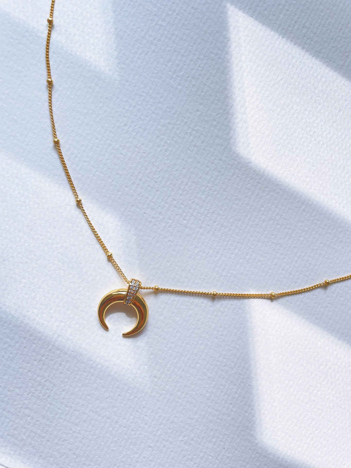 Crescent-shaped pendant necklace